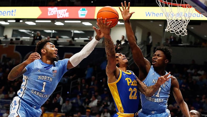Dec 30, 2022; Pittsburgh, Pennsylvania, USA; Pittsburgh Panthers guard Nike Sibande (22) goes to the basket as North Carolina Tar Heels forward Leaky Black (1) and guard D'Marco Dunn (11) defend during the first half at the Petersen Events Center. Mandatory Credit: Charles LeClaire-USA TODAY Sports