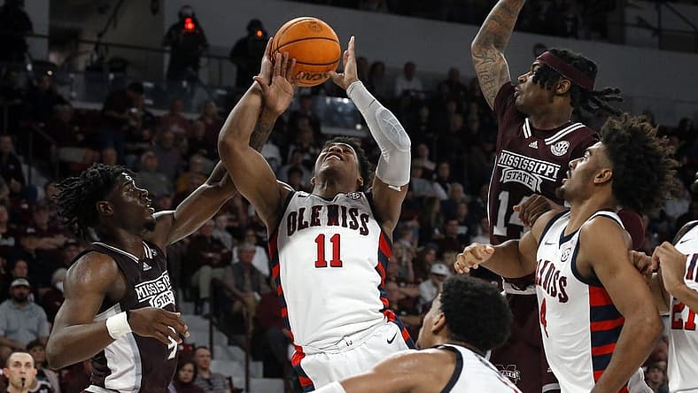 Jan 7, 2023; Starkville, Mississippi, USA; Mississippi Rebels guard Matthew Murrell (11) shoots as Mississippi State Bulldogs guard/forward Cameron Matthews (4) fouls him during the first half at Humphrey Coliseum. Mandatory Credit: Petre Thomas-USA TODAY Sports
