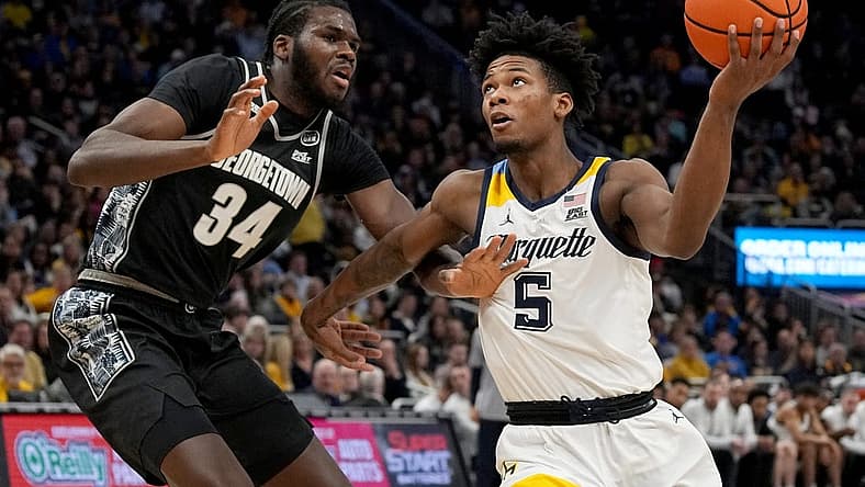 Jan 7, 2023; Milwaukee, Wisconsin, USA; Marquette Golden Eagles guard Chase Ross (5) drives past Georgetown Hoyas center Qudus Wahab (34) during the first half of their game at Fiserv Forum. Mandatory Credit: Mark Hoffman-USA TODAY Sports