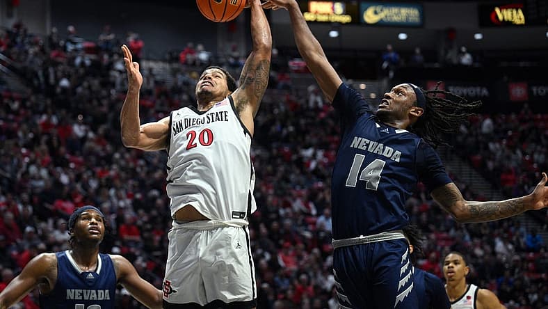Jan 10, 2023; San Diego, California, USA; San Diego State Aztecs guard Matt Bradley (20) goes to the basket while defended by Nevada Wolf Pack forward Tre Coleman (14) during the second half at Viejas Arena. Mandatory Credit: Orlando Ramirez-USA TODAY Sports