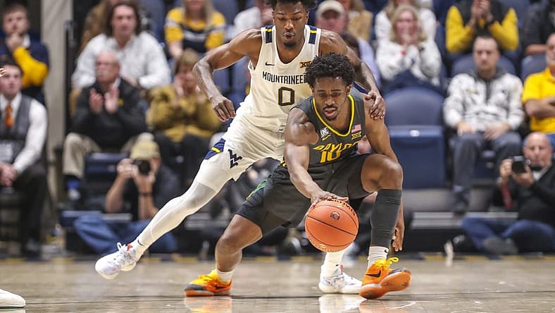 Jan 11, 2023; Morgantown, West Virginia, USA; West Virginia Mountaineers guard Kedrian Johnson (0) defends against Baylor Bears guard Adam Flagler (10) during the second half at WVU Coliseum. Mandatory Credit: Ben Queen-USA TODAY Sports