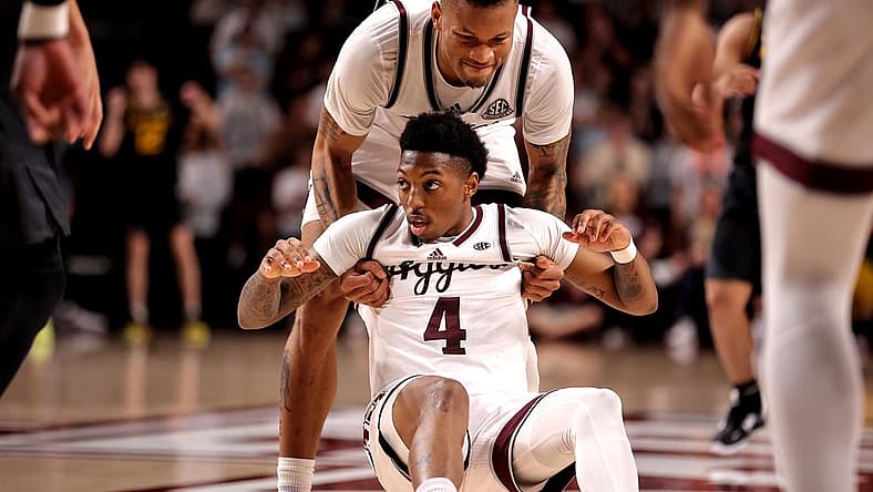 Jan 11, 2023; College Station, Texas, USA; Texas A&M Aggies guard Wade Taylor IV (4) is helped up by guard Dexter Dennis (0) after being fouled against the Missouri Tigers during the second half at Reed Arena. Mandatory Credit: Erik Williams-USA TODAY Sports