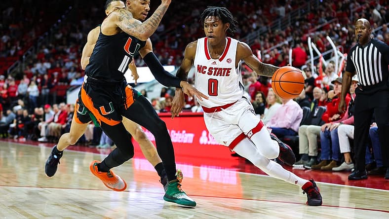 Jan 14, 2023; Raleigh, North Carolina, USA; North Carolina State Wolfpack guard Terquavion Smith (0) runs with the ball guarded by Miami Hurricanes guard Jordan Miller (11) during the first half against Miami Hurricanes at PNC Arena. Mandatory Credit: Jaylynn Nash-USA TODAY Sports