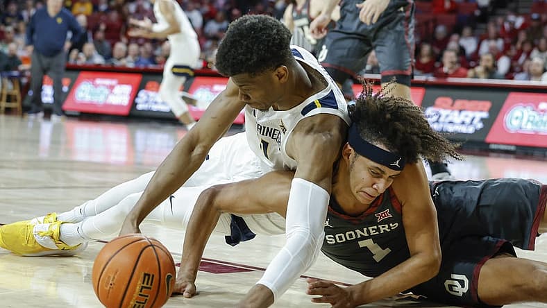Jan 14, 2023; Norman, Oklahoma, USA; West Virginia Mountaineers forward Mohamed Wague (11) and Oklahoma Sooners forward Jalen Hill (1) fight for a loose ball during the first half at Lloyd Noble Center. Mandatory Credit: Alonzo Adams-USA TODAY Sports
