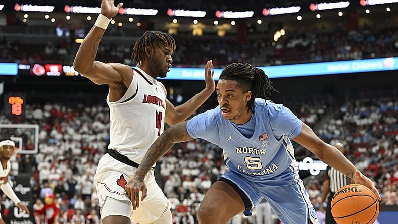 Jan 14, 2023; Louisville, Kentucky, USA; North Carolina Tar Heels forward Armando Bacot (5) dribbles the ball against Louisville Cardinals forward Roosevelt Wheeler (4) during the first half at KFC Yum! Center. Mandatory Credit: Jamie Rhodes-USA TODAY Sports