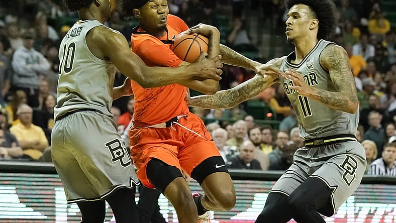 Jan 14, 2023; Waco, Texas, USA; Oklahoma State Cowboys guard Woody Newton (4) drives past Baylor Bears guard Adam Flagler (10) and forward Jalen Bridges (11) during the first half at Ferrell Center. Mandatory Credit: Raymond Carlin III-USA TODAY Sports