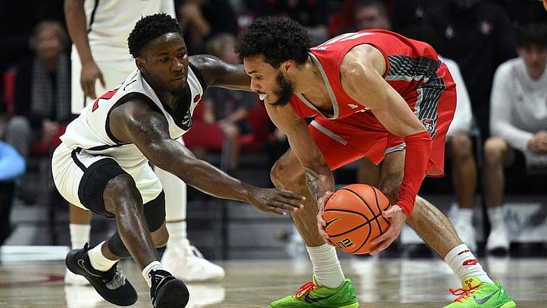 Jan 14, 2023; San Diego, California, USA; New Mexico Lobos guard Jaelen House (10) controls the ball while defended by San Diego State Aztecs guard Darrion Trammell (12) during the first half at Viejas Arena. Mandatory Credit: Orlando Ramirez-USA TODAY Sports