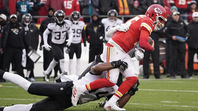 Jan 21, 2023; Kansas City, Missouri, USA; Kansas City Chiefs quarterback Patrick Mahomes (15) is brought down by Jacksonville Jaguars linebacker Travon Walker (44) during the first half in the AFC divisional round game at GEHA Field at Arrowhead Stadium. Mandatory Credit: Denny Medley-USA TODAY Sports