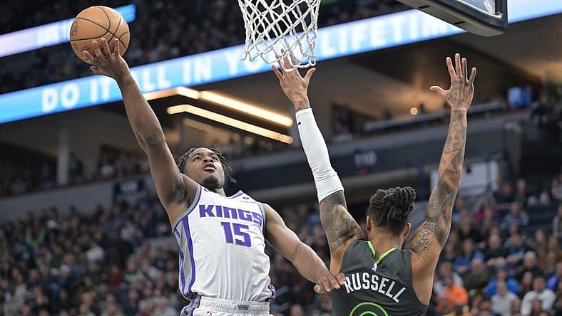 Jan 28, 2023; Minneapolis, Minnesota, USA; Sacramento Kings guard Davion Mitchell (15) goes to the basket as Minnesota Timberwolves guard D'Angelo Russell (0) defends during the second quarter at Target Center. Mandatory Credit: Jeffrey Becker-USA TODAY Sports