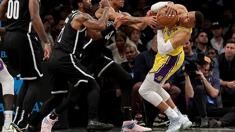 Jan 30, 2023; Brooklyn, New York, USA; Los Angeles Lakers guard Russell Westbrook (0) fights for the ball against Brooklyn Nets guard Kyrie Irving (11) and center Nic Claxton (33) during the first quarter at Barclays Center. Mandatory Credit: Brad Penner-USA TODAY Sports