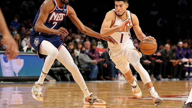 Nov 27, 2021; Brooklyn, New York, USA; Phoenix Suns guard Devin Booker (1) drives with the ball around Brooklyn Nets forward Kevin Durant (7) during the first quarter at Barclays Center. Mandatory Credit: Brad Penner-USA TODAY Sports