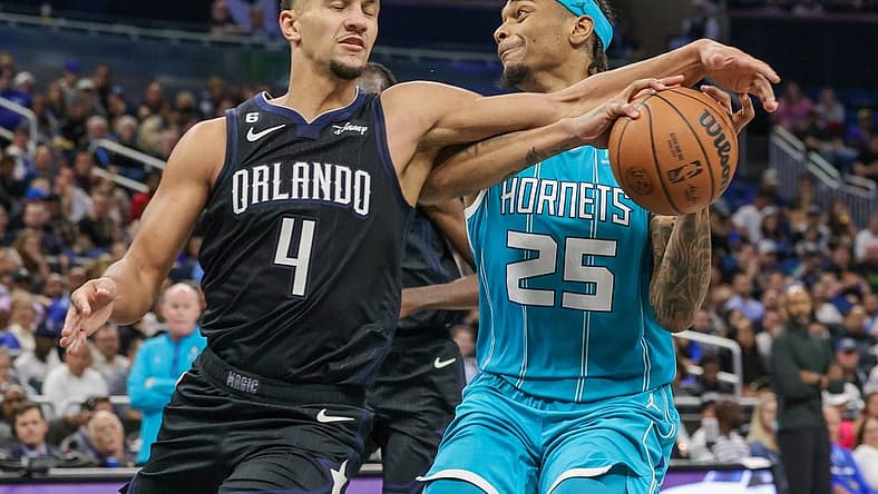 Nov 14, 2022; Orlando, Florida, USA; Orlando Magic guard Jalen Suggs (4) defends Charlotte Hornets forward P.J. Washington (25) during the second quarter at Amway Center. Mandatory Credit: Mike Watters-USA TODAY Sports