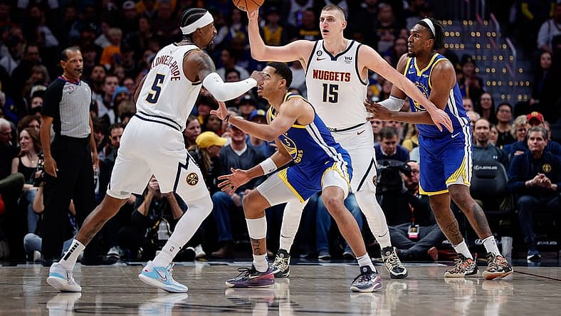Feb 2, 2023; Denver, Colorado, USA; Denver Nuggets center Nikola Jokic (15) controls the ball against Golden State Warriors forward Kevon Looney (5) as guard Kentavious Caldwell-Pope (5) and guard Jordan Poole (3) battle for position in the first quarter at Ball Arena. Mandatory Credit: Isaiah J. Downing-USA TODAY Sports