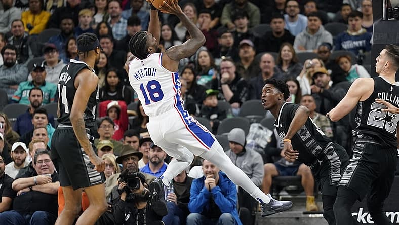 Feb 3, 2023; San Antonio, Texas, USA; Philadelphia 76ers guard Shake Milton (18) shoots over San Antonio Spurs forwards Stanley Johnson (34) and Zach Collins (23) during the first half at AT&T Center. Mandatory Credit: Scott Wachter-USA TODAY Sports