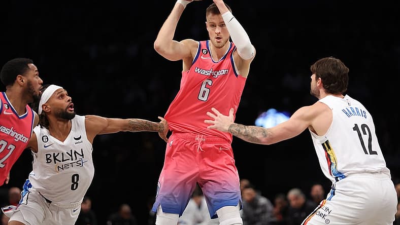 Feb 4, 2023; Brooklyn, New York, USA; Washington Wizards center Kristaps Porzingis (6) controls the ball against Brooklyn Nets guard Patty Mills (8) and forward Joe Harris (12) during the third quarter at Barclays Center. Mandatory Credit: Brad Penner-USA TODAY Sports