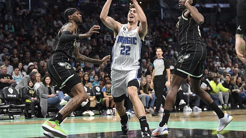 Feb 5, 2023; Charlotte, North Carolina, USA; Orlando Magic forward Franz Wagner (22) drives past Charlotte Hornets forward Jalen McDaniels (6) and center Mark Williams (5) during the first half at the Spectrum Center. Mandatory Credit: Sam Sharpe-USA TODAY Sports