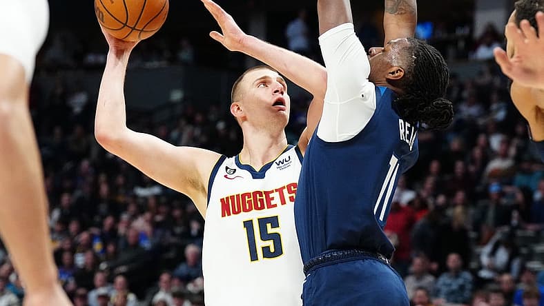 Feb 7, 2023; Denver, Colorado, USA; Denver Nuggets center Nikola Jokic (15) shoots the ball at Minnesota Timberwolves center Naz Reid (11) in the first quarter at Ball Arena. Mandatory Credit: Ron Chenoy-USA TODAY Sports