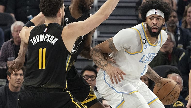 February 11, 2023; San Francisco, California, USA; Los Angeles Lakers forward Anthony Davis (3) dribbles the basketball against Golden State Warriors guard Klay Thompson (11) and forward Andrew Wiggins (22) during the second quarter at Chase Center. Mandatory Credit: Kyle Terada-USA TODAY Sports