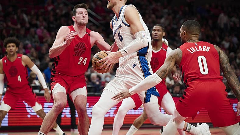 Feb 14, 2023; Portland, Oregon, USA; Washington Wizards center Kristaps Porzingis (6) drives to the basket during the first half against Portland Trail Blazers forward Drew Eubanks (24) and guard Damian Lillard (0) at Moda Center. Mandatory Credit: Troy Wayrynen-USA TODAY Sports