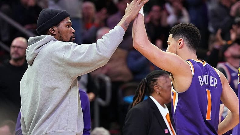 Feb 14, 2023; Phoenix, Arizona, USA; Phoenix Suns forward Kevin Durant slaps hands with Phoenix Suns guard Devin Booker (1) during the second half of the game against the Sacramento Kings at Footprint Center. Mandatory Credit: Joe Camporeale-USA TODAY Sports
