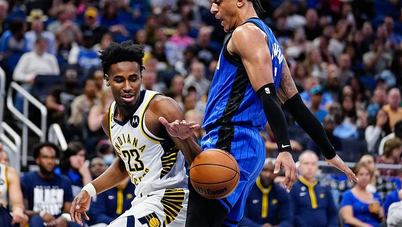 Feb 25, 2023; Orlando, Florida, USA; Indiana Pacers forward Aaron Nesmith (23) dribbles the ball against Orlando Magic forward Paolo Banchero (5) during the second quarter at Amway Center. Mandatory Credit: Rich Storry-USA TODAY Sports