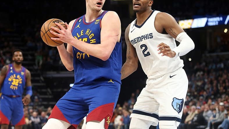 Feb 25, 2023; Memphis, Tennessee, USA; Denver Nuggets center Nikola Jokic (15) spins toward the basket as Memphis Grizzlies forward Xavier Tillman (2) defends during the first half at FedExForum. Mandatory Credit: Petre Thomas-USA TODAY Sports