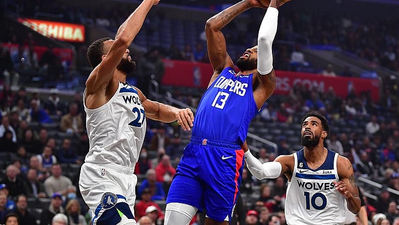 Feb 28, 2023; Los Angeles, California, USA; Los Angeles Clippers forward Paul George (13) shoots against Minnesota Timberwolves center Rudy Gobert (27) and guard Mike Conley (10) during the first half at Crypto.com Arena. Mandatory Credit: Gary A. Vasquez-USA TODAY Sports