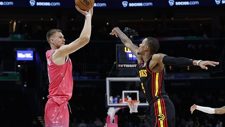 Mar 8, 2023; Washington, District of Columbia, USA; Washington Wizards center Kristaps Porzingis (6) shoots the ball as Atlanta Hawks guard Dejounte Murray (5) defends in the fourth quarter at Capital One Arena. Mandatory Credit: Geoff Burke-USA TODAY Sports