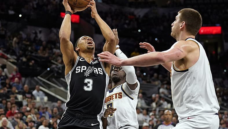 Mar 10, 2023; San Antonio, Texas, USA; San Antonio Spurs forward Keldon Johnson (3) drives to the basket against Denver Nuggets guard Reggie Jackson (7) and center Nikola Jokic (15) during the first half at AT&T Center. Mandatory Credit: Scott Wachter-USA TODAY Sports