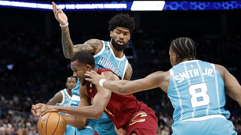 Mar 12, 2023; Charlotte, North Carolina, USA; Cleveland Cavaliers forward Evan Mobley (4) drives through Charlotte Hornets guard Dennis Smith Jr. (8) and center Nick Richards (4) during the first half at Spectrum Center. Mandatory Credit: Brian Westerholt-USA TODAY Sports