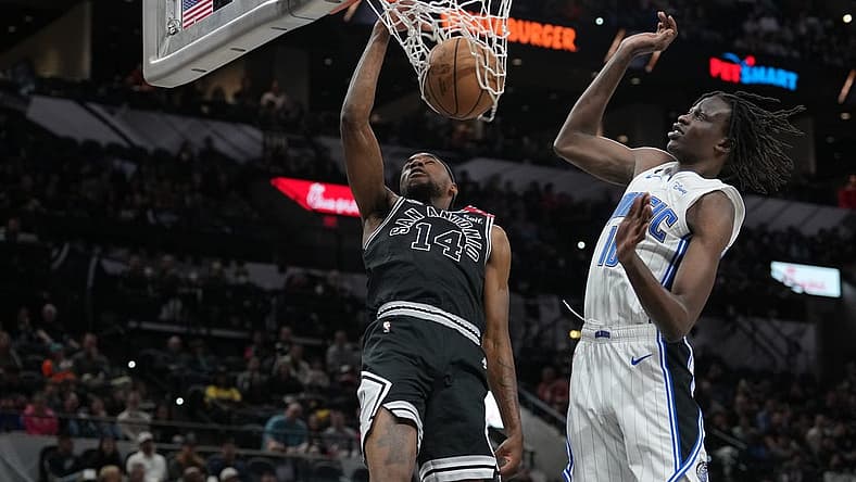 Mar 14, 2023; San Antonio, Texas, USA;  San Antonio Spurs guard Blake Wesley (14) dunks against Orlando Magic center Bol Bol (10) in the first half at the AT&T Center. Mandatory Credit: Daniel Dunn-USA TODAY Sports