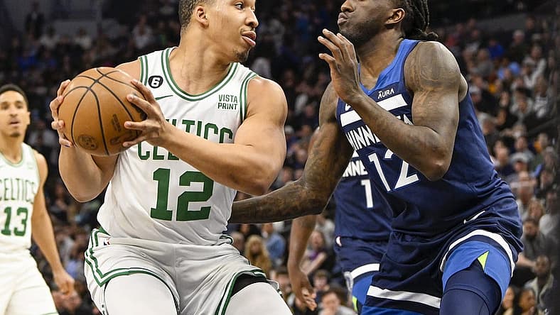Mar 15, 2023; Minneapolis, Minnesota, USA;  Boston Celtics forward Grant Williams (12) protects the ball from Minnesota Timberwolves forward Taurean Prince (12) in the first quarter at Target Center. Mandatory Credit: Nick Wosika-USA TODAY Sports