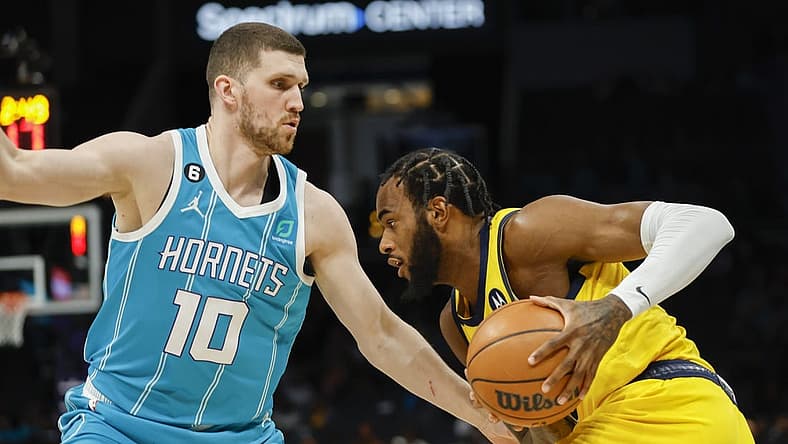 Mar 20, 2023; Charlotte, North Carolina, USA; Indiana Pacers forward Oshae Brissett (12) drives against Charlotte Hornets guard Svi Mykhailiuk (10) during the first half at Spectrum Center. Mandatory Credit: Nell Redmond-USA TODAY Sports