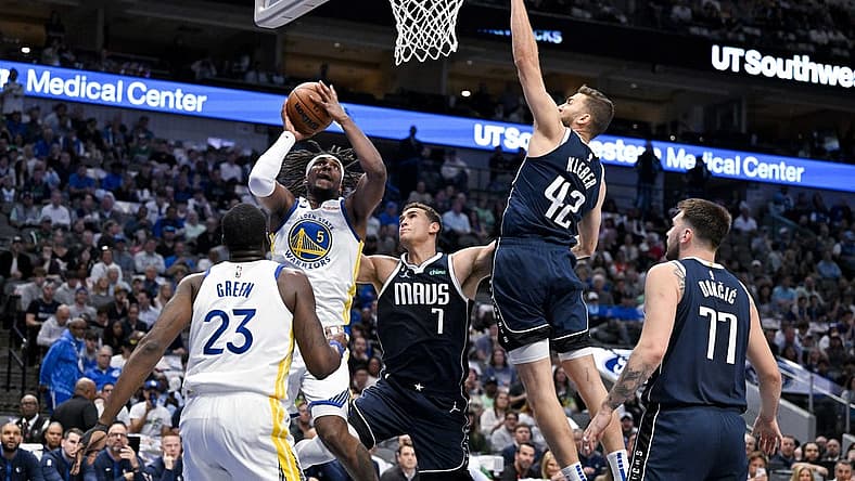Mar 22, 2023; Dallas, Texas, USA; Golden State Warriors forward Kevon Looney (5) shoots over Dallas Mavericks center Dwight Powell (7) and forward Maxi Kleber (42) and guard Luka Doncic (77) during the first quarter at the American Airlines Center. Mandatory Credit: Jerome Miron-USA TODAY Sports