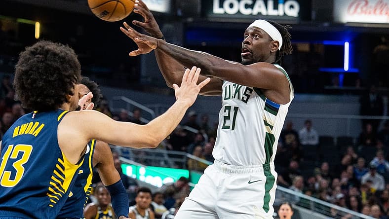 Mar 29, 2023; Indianapolis, Indiana, USA; Milwaukee Bucks guard Jrue Holiday (21) passes the ball while Indiana Pacers forward Jordan Nwora (13) defends in the second quarter at Gainbridge Fieldhouse. Mandatory Credit: Trevor Ruszkowski-USA TODAY Sports