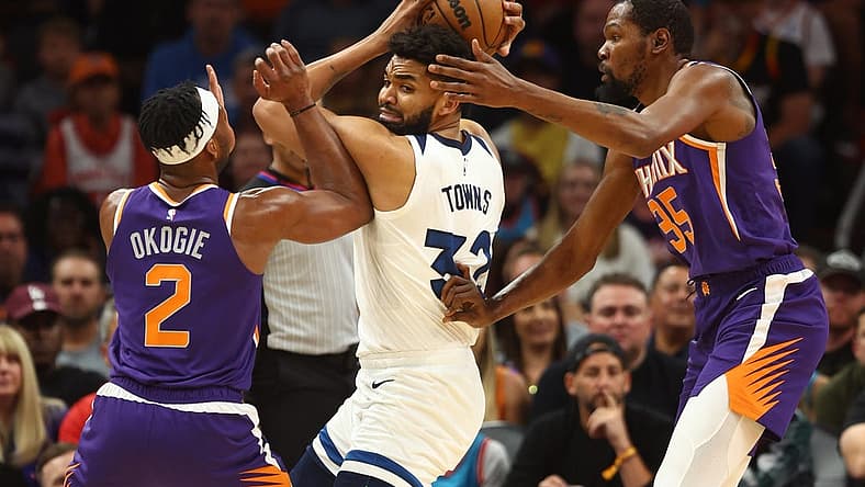 Mar 29, 2023; Phoenix, Arizona, USA; Minnesota Timberwolves center Karl-Anthony Towns (32) controls the ball against Phoenix Suns forward Josh Okogie (2) and Kevin Durant (35) in the first half at Footprint Center. Mandatory Credit: Mark J. Rebilas-USA TODAY Sports