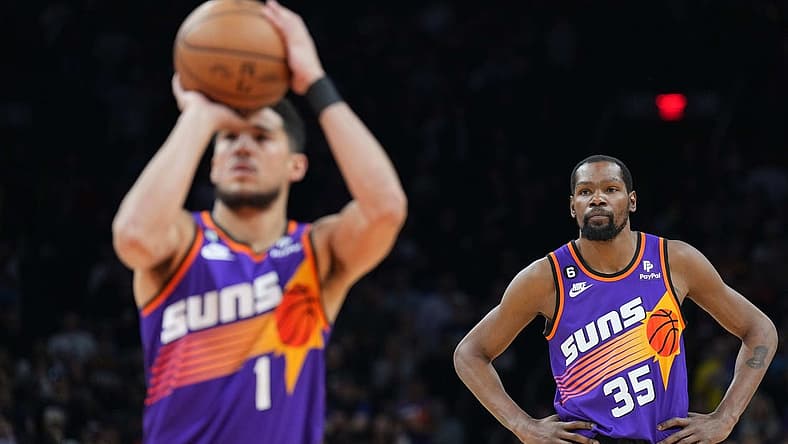 Mar 31, 2023; Phoenix, Arizona, USA; Phoenix Suns forward Kevin Durant (35) watches as Phoenix Suns guard Devin Booker (1) shoots a free throw against the Denver Nuggets during the first half at Footprint Center. Mandatory Credit: Joe Camporeale-USA TODAY Sports