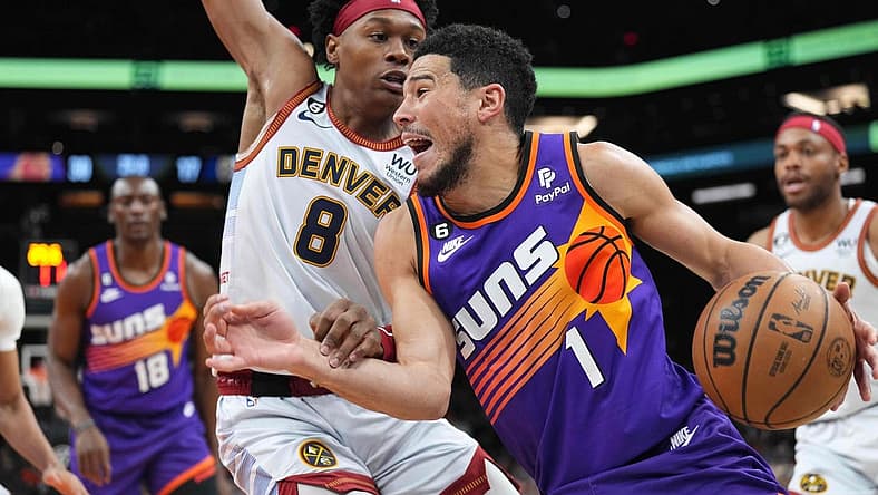 Mar 31, 2023; Phoenix, Arizona, USA; Phoenix Suns guard Devin Booker (1) dribbles against Denver Nuggets forward Peyton Watson (8) during the first half at Footprint Center. Mandatory Credit: Joe Camporeale-USA TODAY Sports