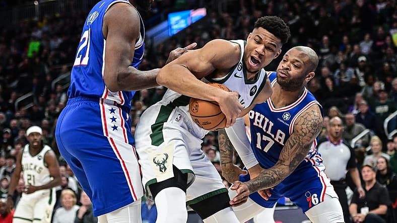 Apr 2, 2023; Milwaukee, Wisconsin, USA; Milwaukee Bucks forward Giannis Antetokounmpo (34) fights for the ball against Philadelphia 76ers forward P.J. Tucker (17) and forward Joel Embiid (21) during the first quarter at Fiserv Forum. Mandatory Credit: Benny Sieu-USA TODAY Sports