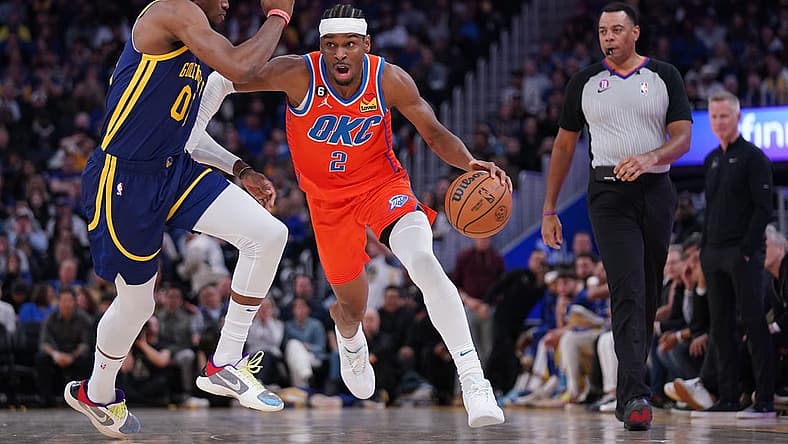 Apr 4, 2023; San Francisco, California, USA; Oklahoma City Thunder guard Shai Gilgeous-Alexander (2) dribbles past Golden State Warriors forward Jonathan Kuminga (00) in the second quarter at the Chase Center. Mandatory Credit: Cary Edmondson-USA TODAY Sports