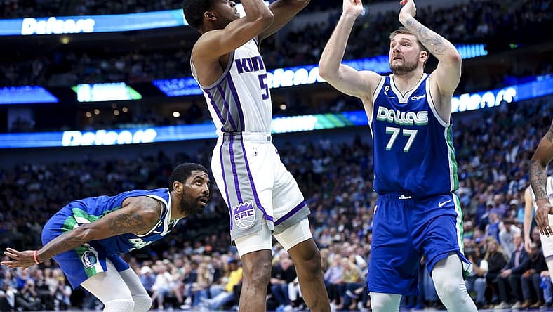Apr 5, 2023; Dallas, Texas, USA; Sacramento Kings guard De'Aaron Fox (5) shoots as Dallas Mavericks guard Kyrie Irving (2) and Dallas Mavericks guard Luka Doncic (77) defend during the fourth quarter at American Airlines Center. Mandatory Credit: Kevin Jairaj-USA TODAY Sports