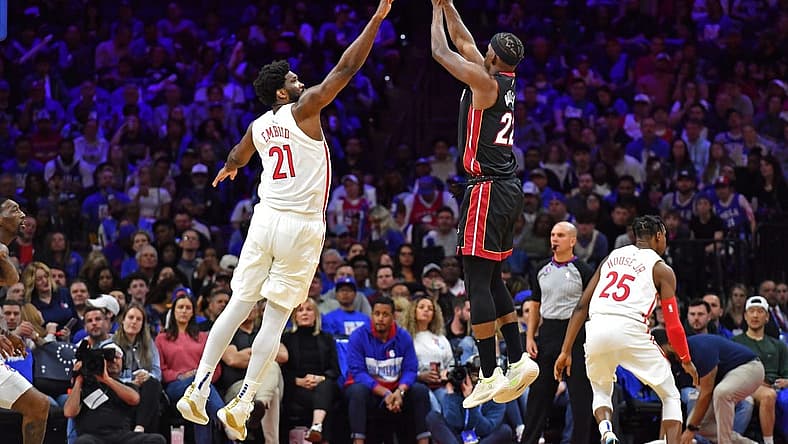 Apr 6, 2023; Philadelphia, Pennsylvania, USA; Miami Heat forward Jimmy Butler (22) shoots a three pointer shot over Philadelphia 76ers center Joel Embiid (21) during the third quarter at Wells Fargo Center. Mandatory Credit: Eric Hartline-USA TODAY Sports