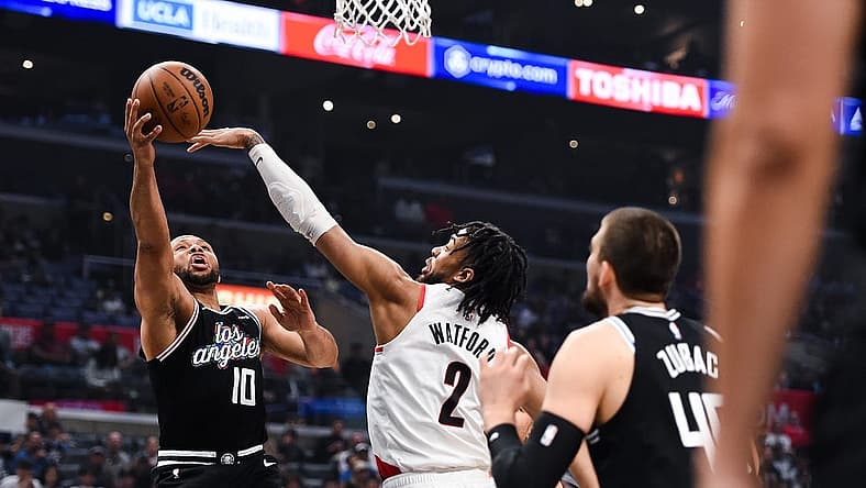 Apr 8, 2023; Los Angeles, California, USA; LA Clippers guard Eric Gordon (10) grabs a rebound against Portland Trail Blazers forward Trendon Watford (2) during the first quarter at Crypto.com Arena. Mandatory Credit: Jonathan Hui-USA TODAY Sports