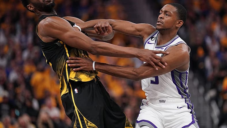 Apr 20, 2023; San Francisco, California, USA; Golden State Warriors forward Andrew Wiggins (22) is fouled by Sacramento Kings guard De'Aaron Fox (5) in the second quarter during game three of the 2023 NBA playoffs at the Chase Center. Mandatory Credit: Cary Edmondson-USA TODAY Sports