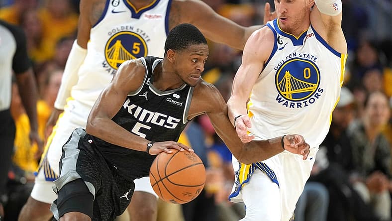 Apr 23, 2023; San Francisco, California, USA; Sacramento Kings guard Malik Monk (0) dribbles against Golden State Warriors guard Donte DiVincenzo (0) during the third quarter of game four of the 2023 NBA playoffs at Chase Center. Mandatory Credit: Darren Yamashita-USA TODAY Sports