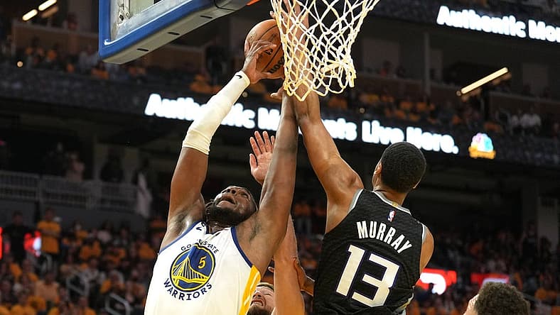 Apr 23, 2023; San Francisco, California, USA; Golden State Warriors forward Kevon Looney (5) reaches for a rebound against Sacramento Kings forward Keegan Murray (13) and forward Domantas Sabonis (lower center) during the third quarter of game four of the 2023 NBA playoffs at Chase Center. Mandatory Credit: Darren Yamashita-USA TODAY Sports