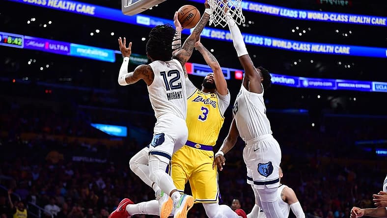 Apr 24, 2023; Los Angeles, California, USA; Los Angeles Lakers forward Anthony Davis (3) moves to the basket against Memphis Grizzlies guard Ja Morant (12) and forward Jaren Jackson Jr. (13) during the first half in game four of the 2023 NBA playoffs at Crypto.com Arena. Mandatory Credit: Gary A. Vasquez-USA TODAY Sports