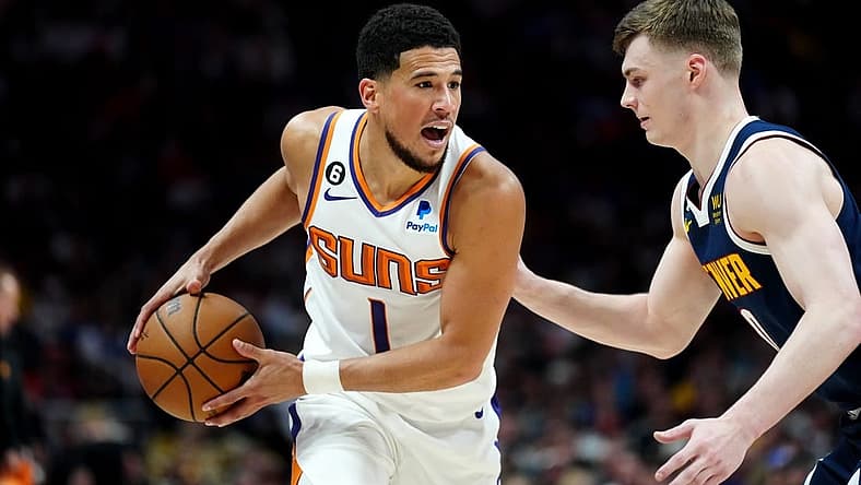 May 1, 2023; Denver, Colorado, USA; Phoenix Suns guard Devin Booker (1) and Denver Nuggets guard Christian Braun (0) in the first half during game two of the 2023 NBA playoffs at Ball Arena. Mandatory Credit: Ron Chenoy-USA TODAY Sports