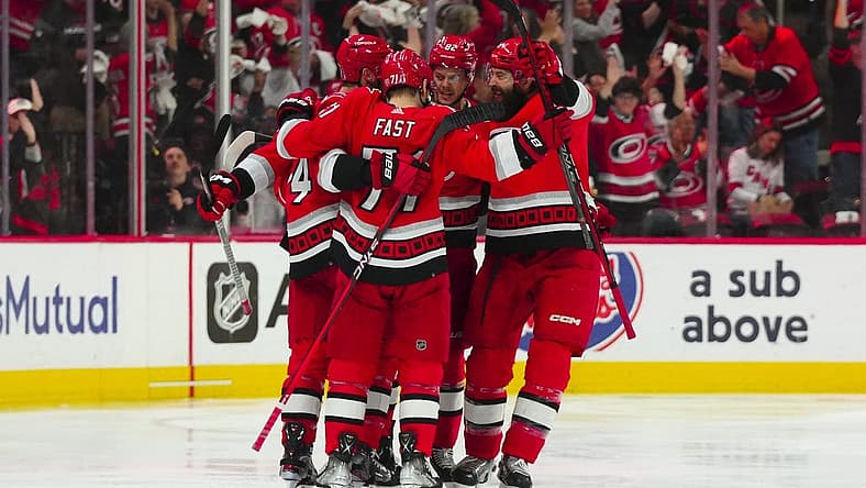 May 11, 2023; Raleigh, North Carolina, USA; Carolina Hurricanes center Jesperi Kotkaniemi (82) is congratulated by right wing Jesper Fast (71) defenseman Brent Burns (8) and defenseman Jaccob Slavin (74) after his goal against the New Jersey Devils during the second period in game five of the second round of the 2023 Stanley Cup Playoffs at PNC Arena. Mandatory Credit: James Guillory-USA TODAY Sports