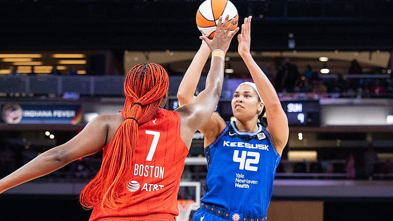 May 19, 2023; Indianapolis, Indiana, USA; Connecticut Sun center Brionna Jones (42) shoots the ball while Indiana Fever forward Aliyah Boston (7) defends in the first half at Gainbridge Fieldhouse. Mandatory Credit: Trevor Ruszkowski-USA TODAY Sports